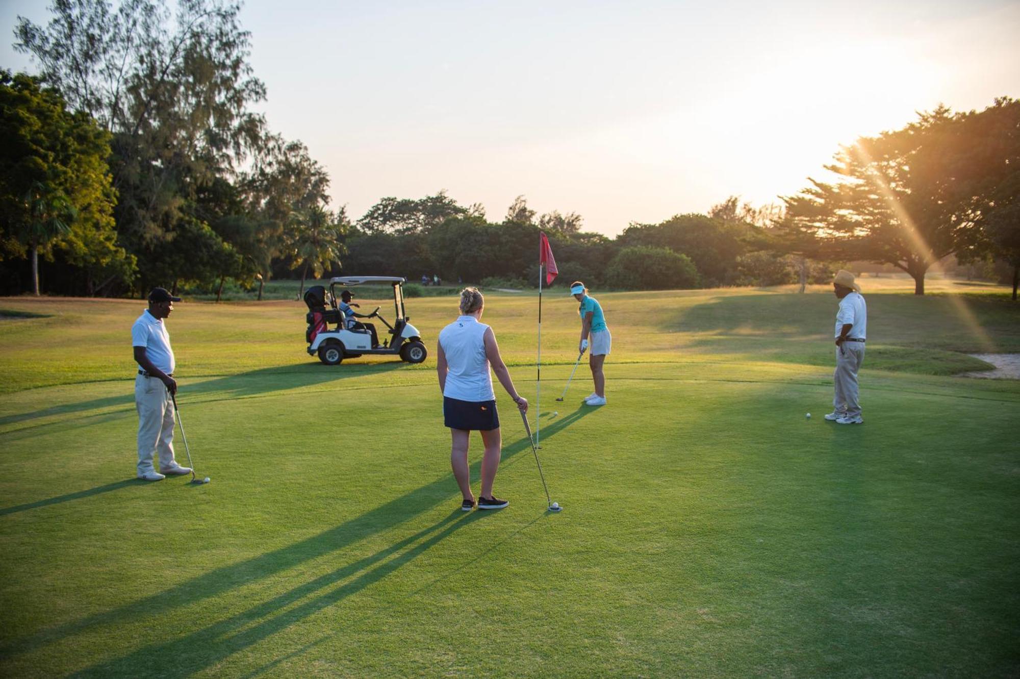 منتجع ليجر لودج بيتش آند جولف شاطئ دياني المظهر الخارجي الصورة Golfers putting on the 18th green at the Royal Pines Resort